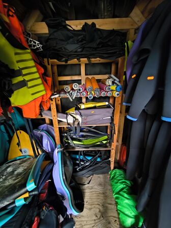 Våddragter, redningsveste, paddelboards m.v. i skur 