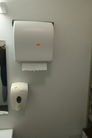 Reol med indhold samt papirdispenser