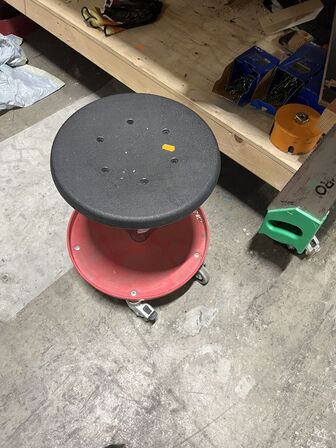 Bord med indhold på nederste hylde samt taburet