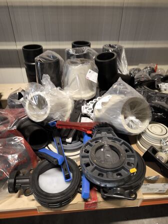 Indhold af fittings og reservedele på reol