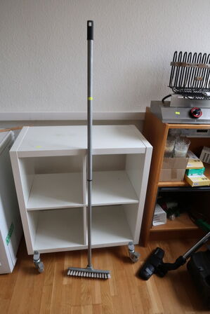 Shelves with contents as well as bread cutters and cleaning supplies