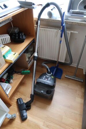 Shelves with contents as well as bread cutters and cleaning supplies