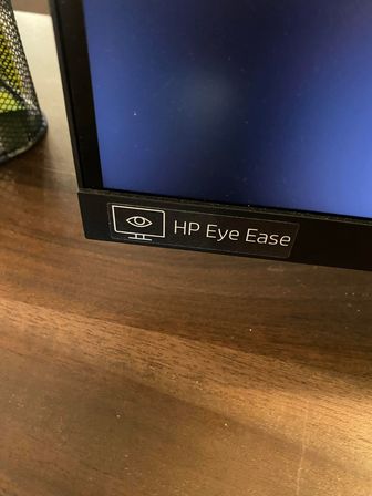 Computerskrm HP EYE EASE samt indhold på bord